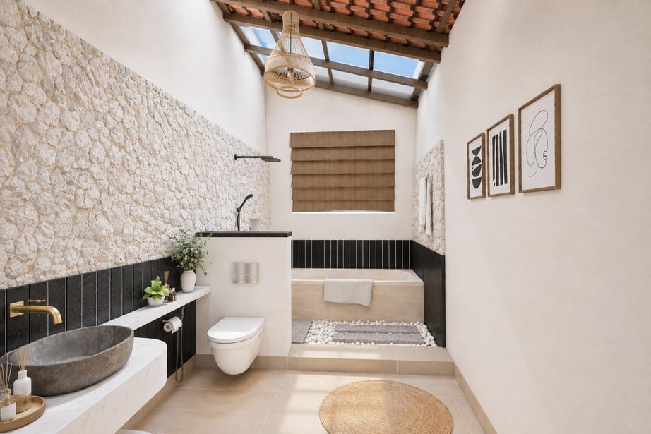 Skylit bathroom with rough stone walls, dark vertical tiling and a stone vessel basin
